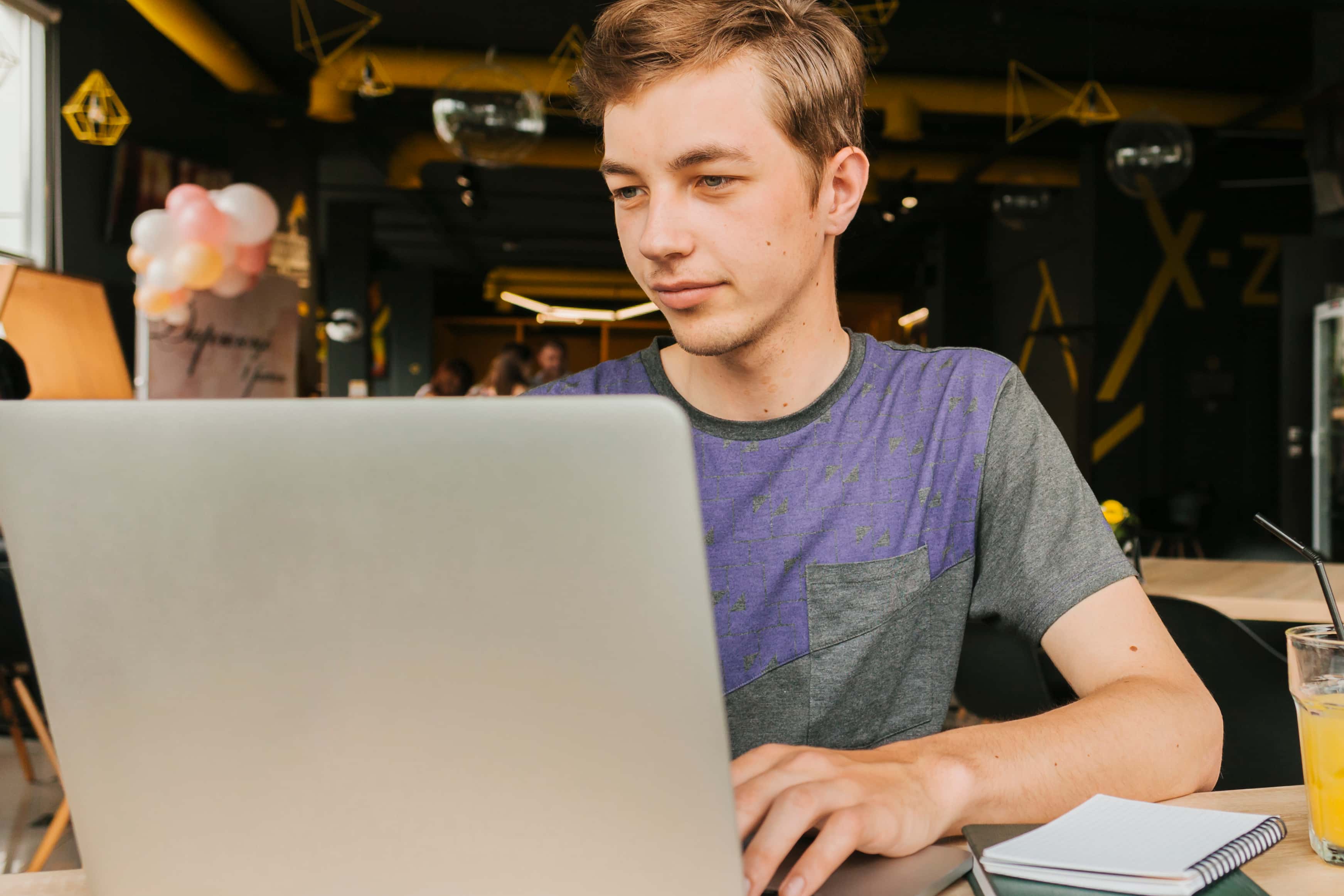 Student technikum programistycznego online pracuje na laptopie w kawiarni